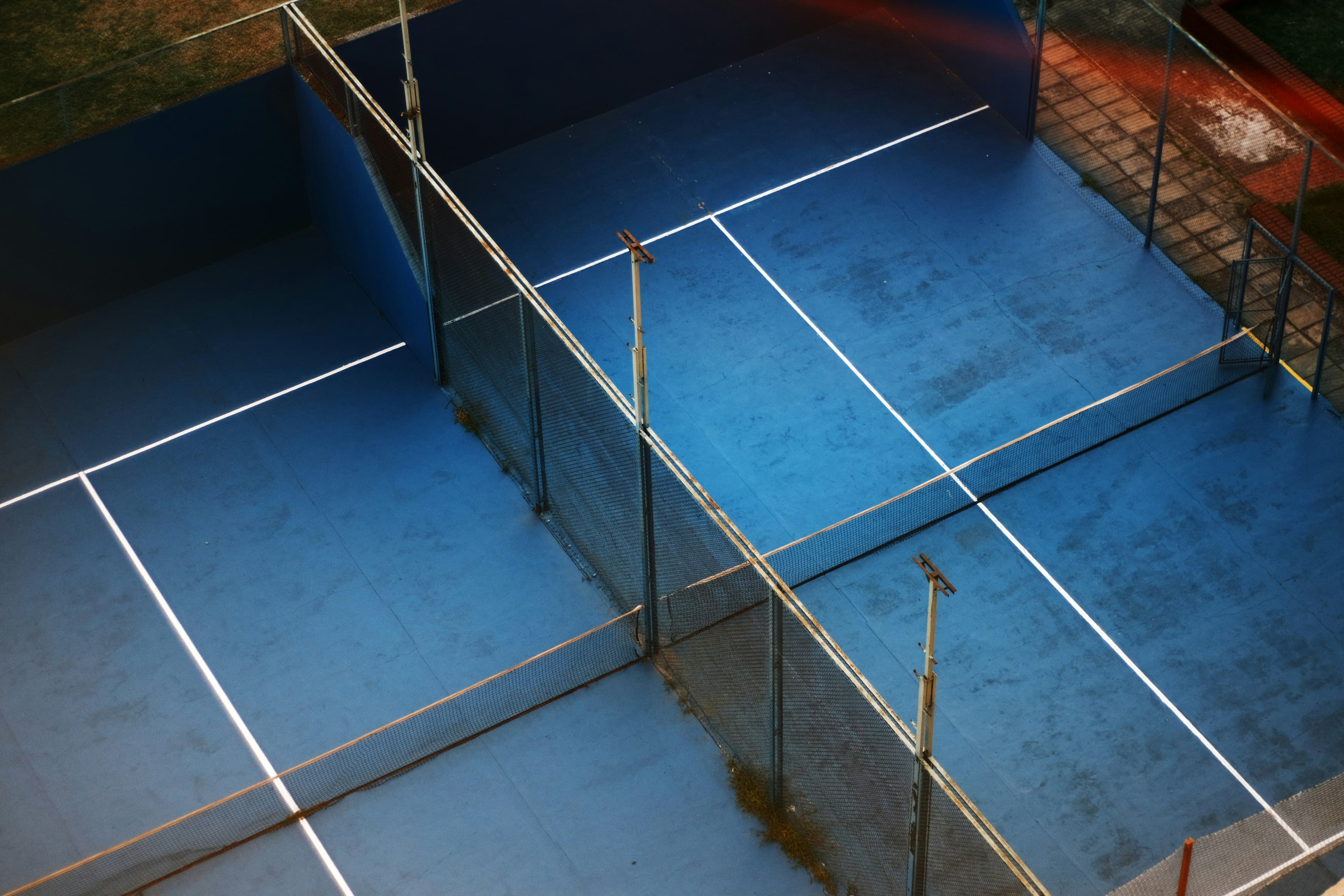Angled view over blue padel courts at night